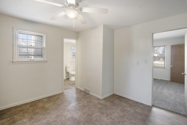 unfurnished room with visible vents, baseboards, and ceiling fan