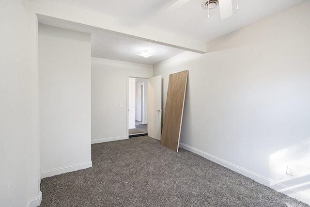 carpeted spare room featuring beamed ceiling, baseboards, and a ceiling fan