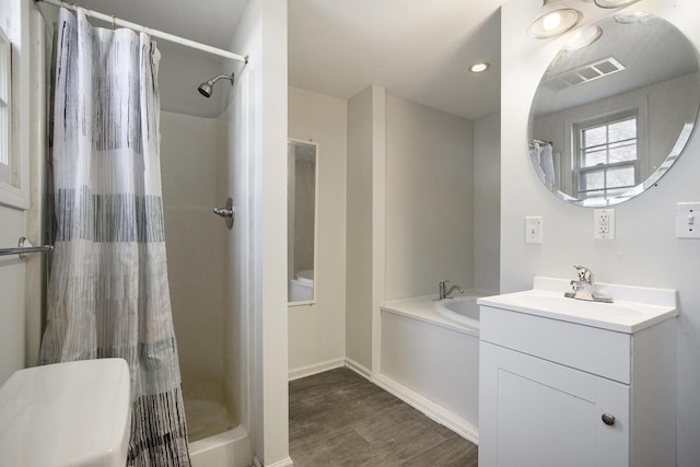 bathroom featuring visible vents, a garden tub, a stall shower, wood finished floors, and vanity