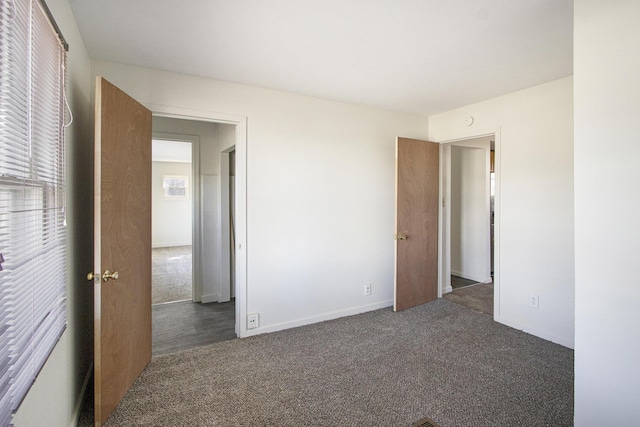 unfurnished bedroom with baseboards and carpet floors