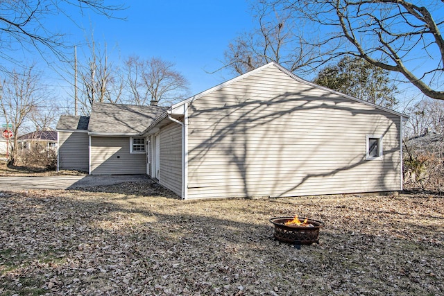 view of side of property featuring an outdoor fire pit