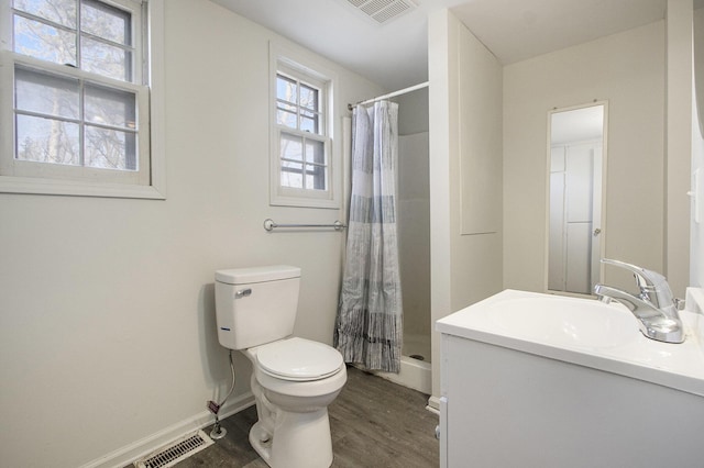 full bathroom featuring vanity, a shower with curtain, wood finished floors, visible vents, and toilet