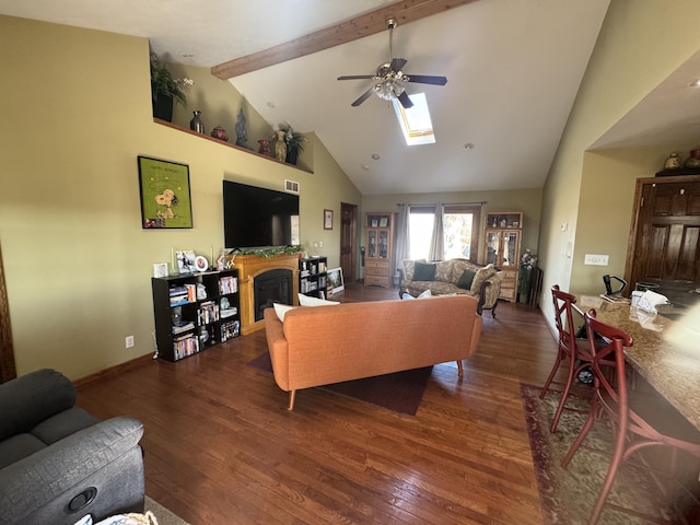 living room with hardwood / wood-style floors, beamed ceiling, a ceiling fan, and a fireplace