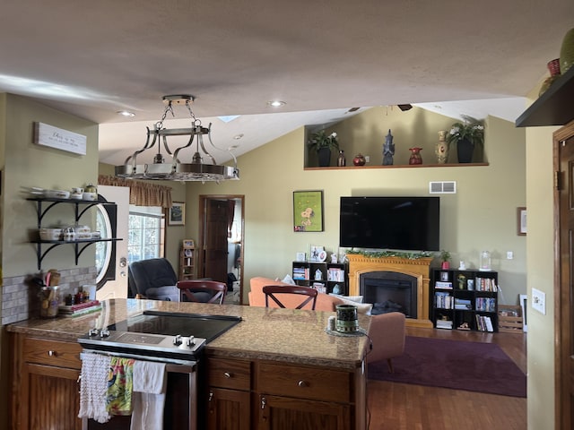 kitchen featuring visible vents, dark wood-type flooring, open floor plan, vaulted ceiling, and stainless steel range with electric cooktop