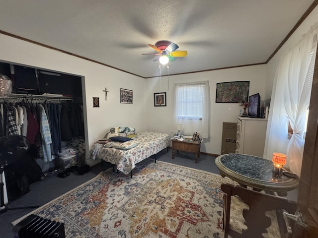 bedroom featuring a textured ceiling, a ceiling fan, a closet, and ornamental molding