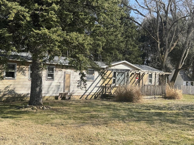 view of front facade featuring a front yard and a wooden deck