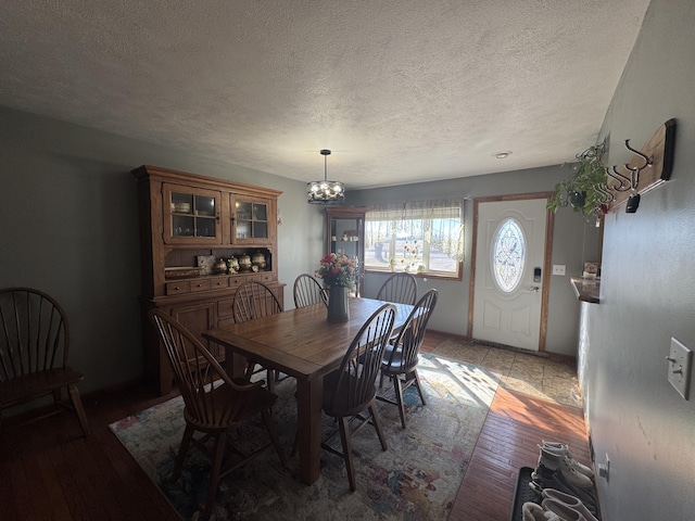 dining room with a chandelier, a textured ceiling, and hardwood / wood-style floors