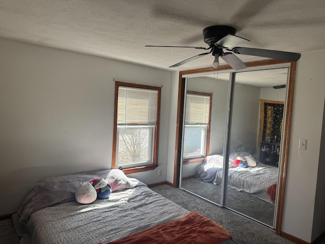 bedroom featuring a closet, carpet flooring, multiple windows, and a textured ceiling