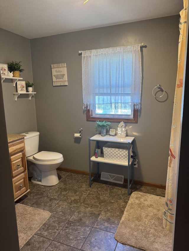 bathroom with toilet and baseboards