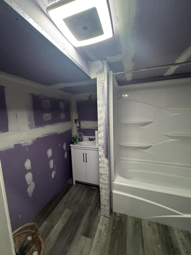 bathroom with vanity, bathing tub / shower combination, and wood finished floors