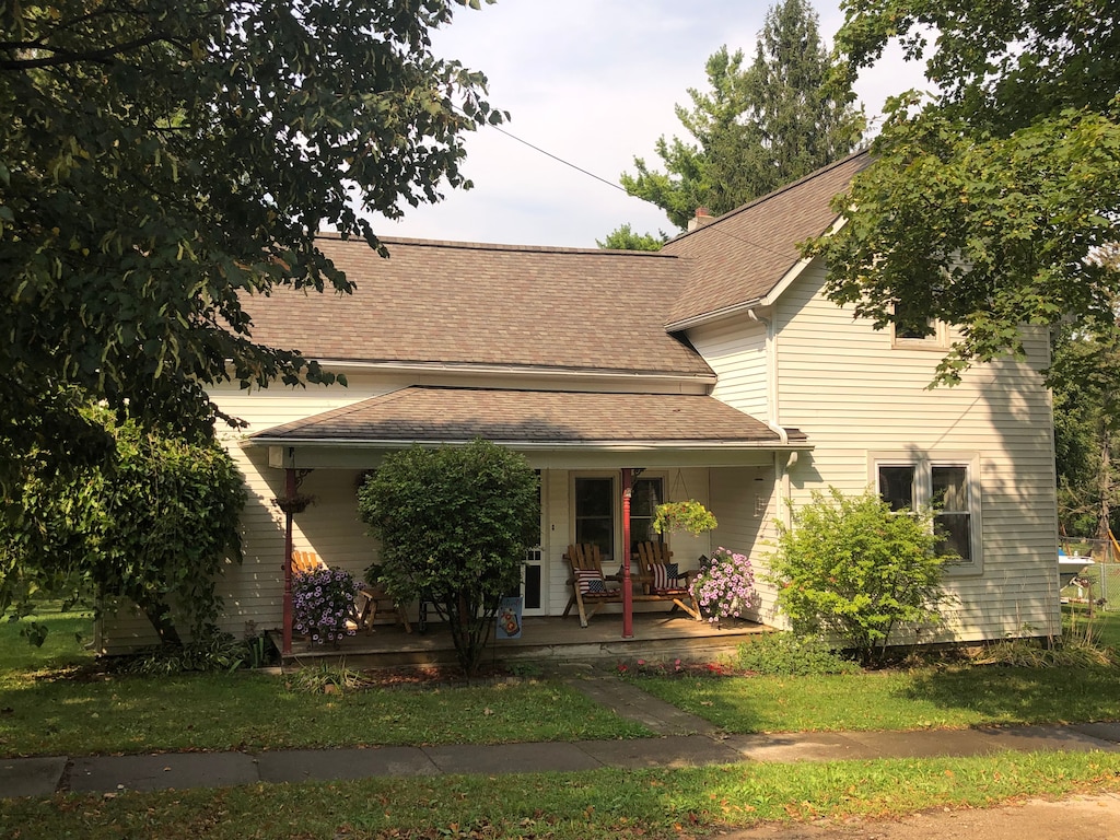 view of front facade featuring covered porch and roof with shingles