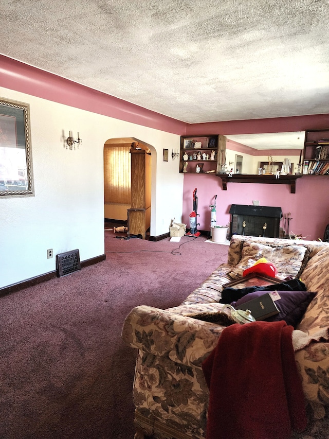 living area with arched walkways, a textured ceiling, baseboards, and carpet