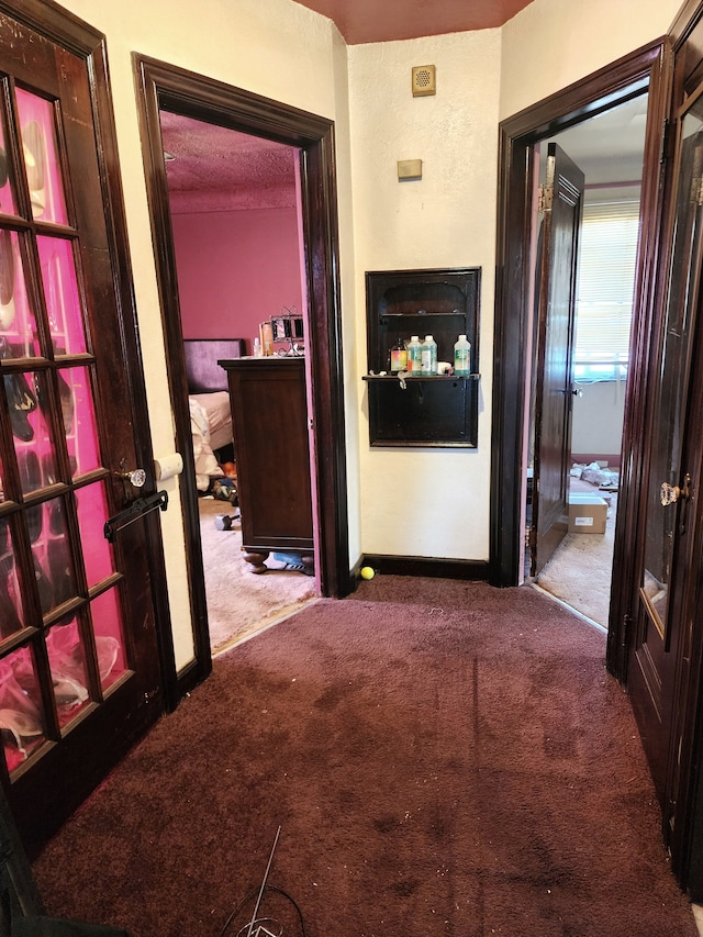 corridor with baseboards and carpet