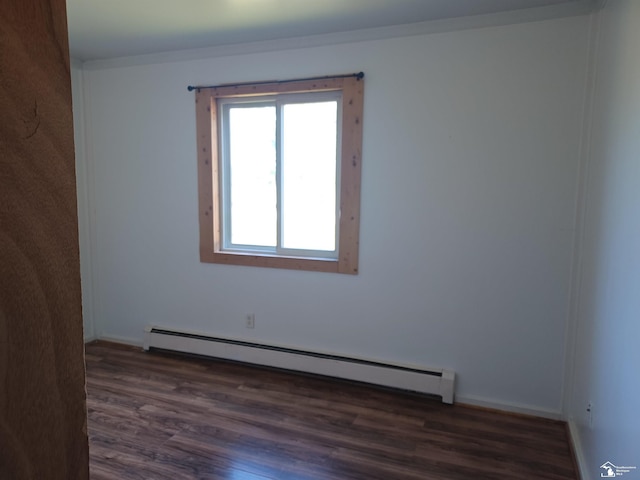 spare room featuring wood finished floors and a baseboard radiator