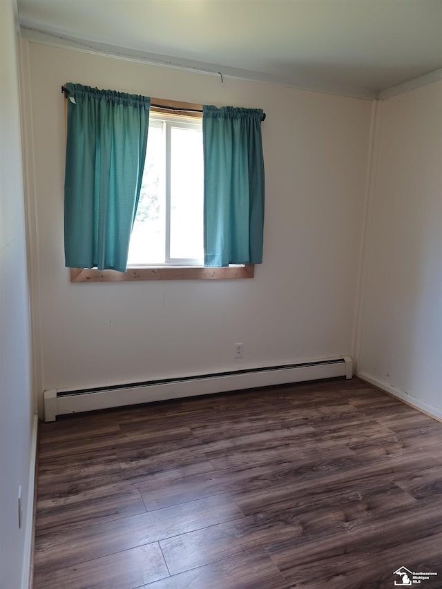 empty room featuring dark wood-style floors and baseboard heating