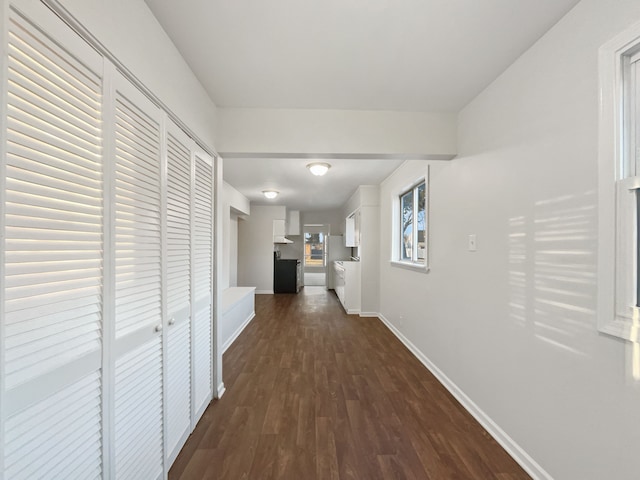 corridor featuring dark wood-style floors and baseboards