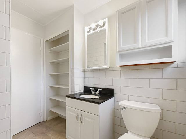 bathroom featuring built in features, toilet, tile walls, and vanity