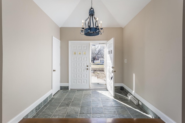 foyer entrance featuring vaulted ceiling, baseboards, and a chandelier