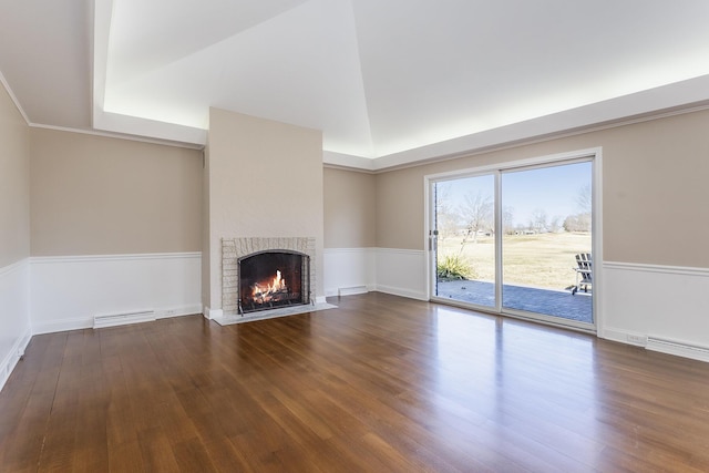 unfurnished living room with visible vents, a fireplace, and wood finished floors