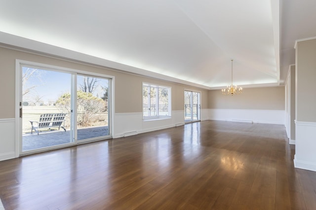 unfurnished room featuring visible vents, an inviting chandelier, dark wood-style floors, and wainscoting