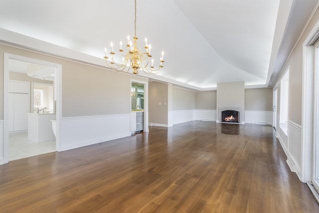 unfurnished living room featuring a chandelier, dark wood finished floors, a fireplace, and lofted ceiling