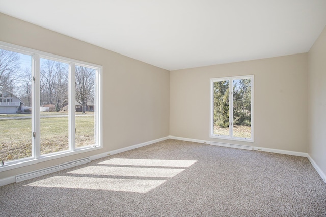 unfurnished room featuring plenty of natural light, baseboards, and carpet