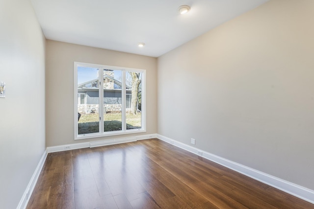 empty room featuring dark wood-style floors and baseboards