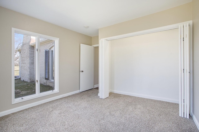 unfurnished bedroom featuring carpet, baseboards, and a closet