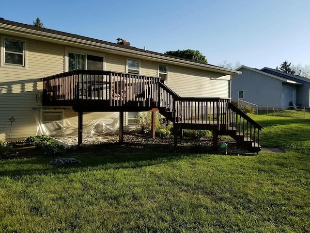 rear view of house with a chimney, stairway, a wooden deck, and a yard