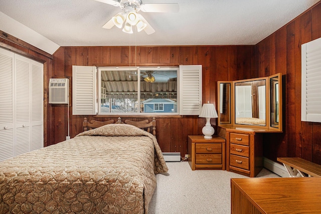 carpeted bedroom with a baseboard heating unit, wooden walls, and a closet