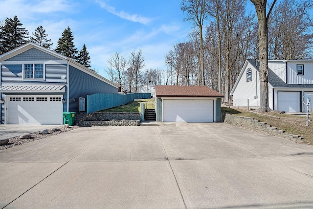 view of home's exterior featuring an outdoor structure, fence, and a garage