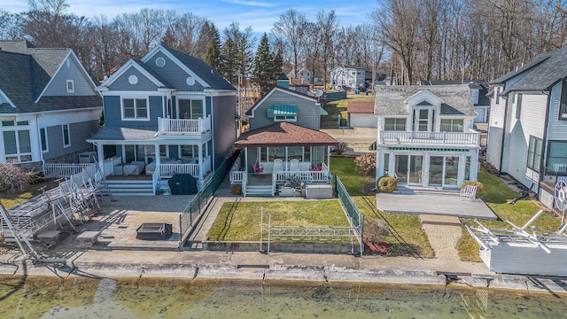 rear view of house with a patio area, a yard, fence private yard, and a balcony