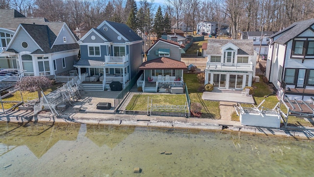 back of house featuring a patio, a balcony, a shingled roof, fence private yard, and a residential view