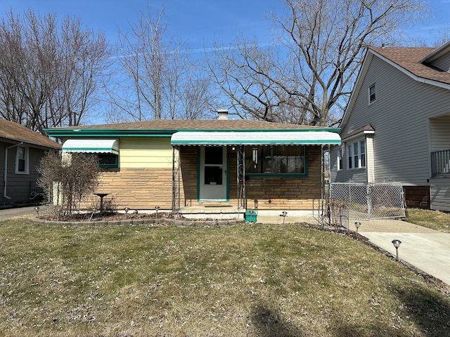 view of front of property with stone siding, a front yard, and roof with shingles