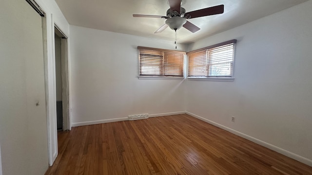 unfurnished bedroom featuring a closet, baseboards, visible vents, and wood finished floors