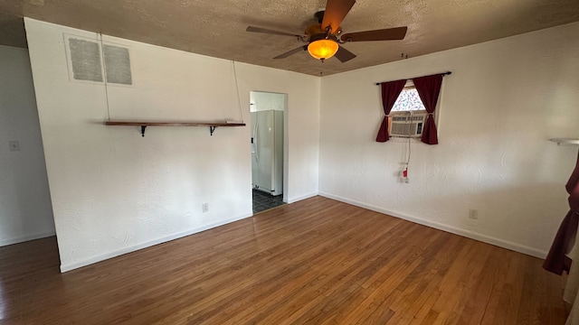 spare room with baseboards, a textured ceiling, wood finished floors, and a ceiling fan