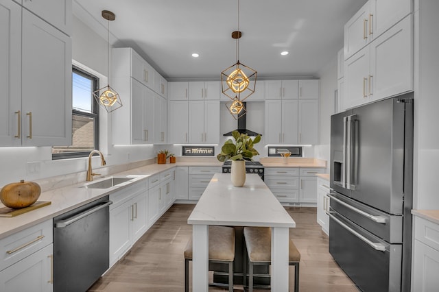 kitchen featuring a sink, stainless steel appliances, white cabinetry, and wall chimney range hood