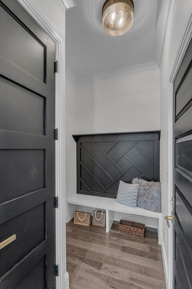 mudroom with wood finished floors and ornamental molding