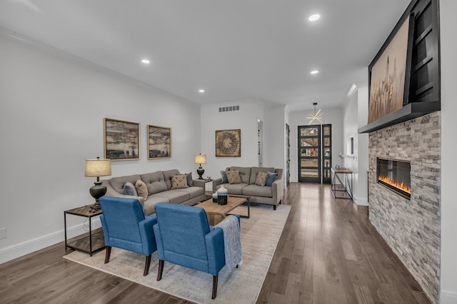 living area with recessed lighting, visible vents, a brick fireplace, and dark wood-style flooring