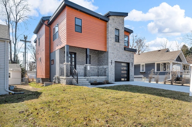 back of property featuring a lawn, driveway, stone siding, covered porch, and an attached garage