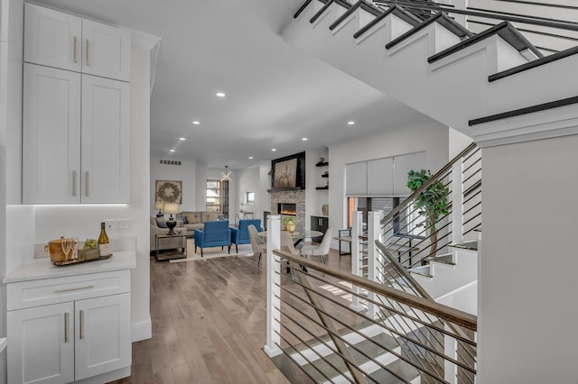 hall with recessed lighting, stairway, visible vents, and wood finished floors