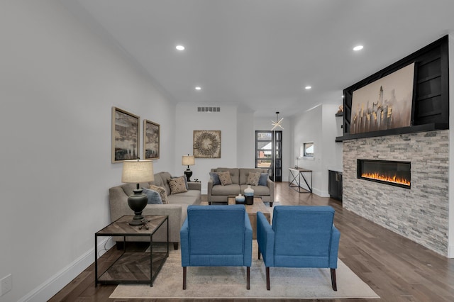 living area featuring visible vents, recessed lighting, a stone fireplace, and wood finished floors