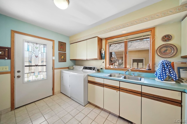 washroom with cabinet space, a healthy amount of sunlight, washing machine and dryer, and a sink