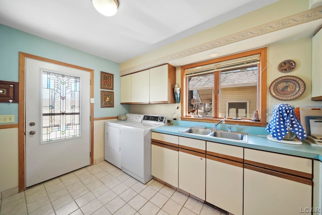 laundry room featuring a sink, cabinet space, independent washer and dryer, and light tile patterned floors