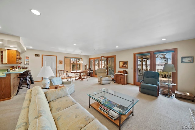 living area featuring recessed lighting, a wealth of natural light, and light carpet