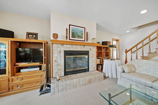 living area with carpet flooring, recessed lighting, stairs, and a tile fireplace