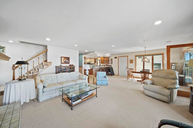 living room featuring recessed lighting, an inviting chandelier, stairs, and carpet