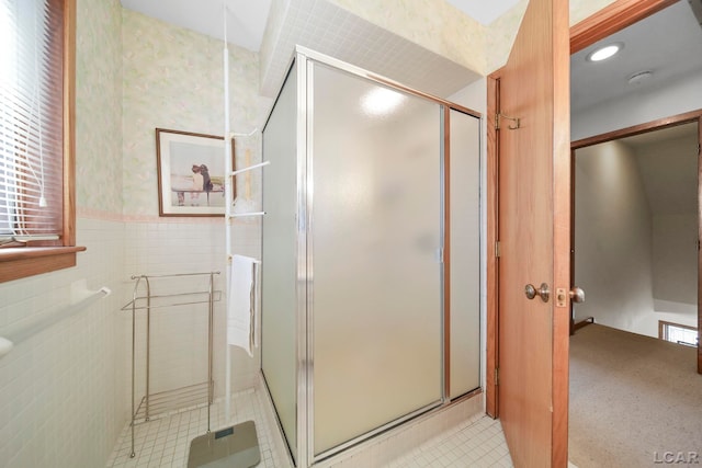 full bath with tile walls, a shower stall, a wainscoted wall, tile patterned floors, and wallpapered walls