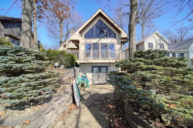 back of property with french doors and a chimney