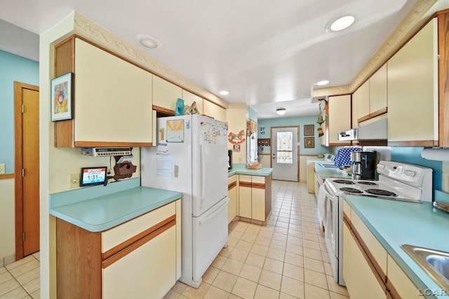 kitchen with light tile patterned floors, light countertops, recessed lighting, and white appliances